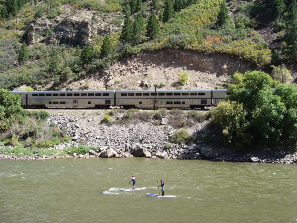 California Zephyr in Glenwood Canyon with Colorado River and paddleboarders